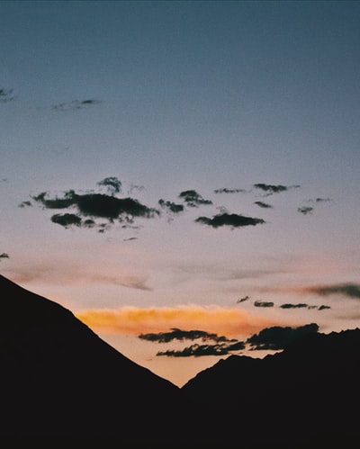 夕阳下飞过山头的鸟的剪影